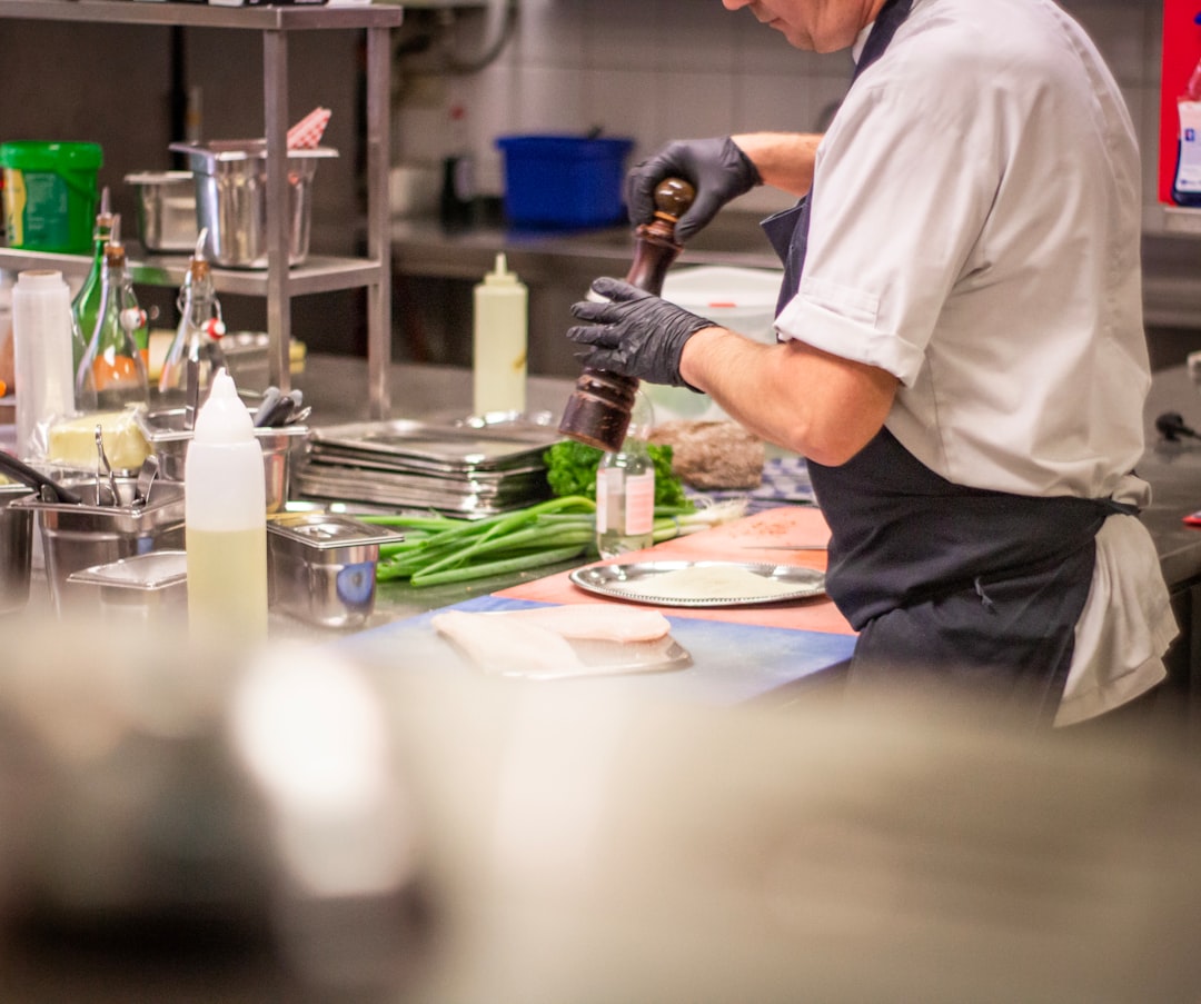 A chef carefully plates an elegant course at a Manhattan restaurant during restaurant week NYC, showcasing culinary craft.