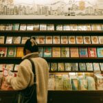 A young child browsing picture books at one of the best children's bookstores in NYC, surrounded by colorful shelves.