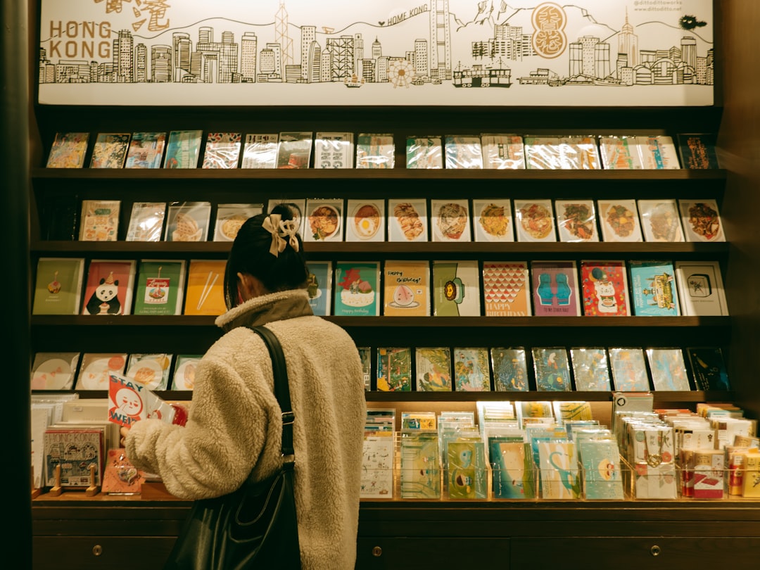 A young child browsing picture books at one of the best children's bookstores in NYC, surrounded by colorful shelves.