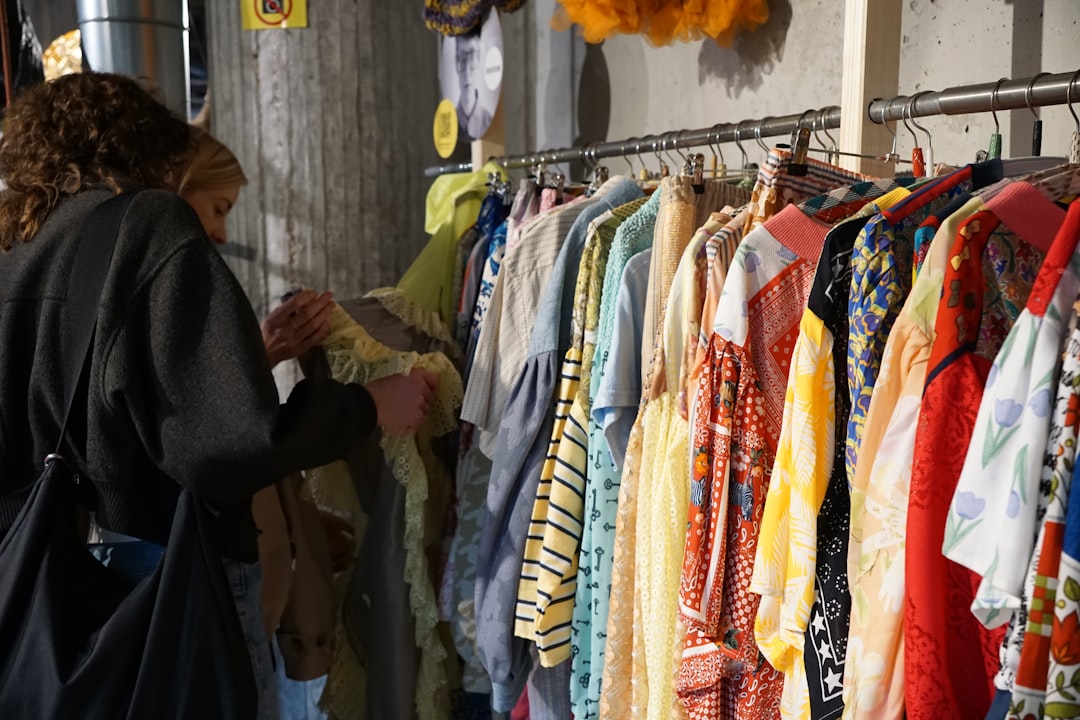 A woman carefully browsing a rack of vintage clothing at a curated secondhand store in New York City
