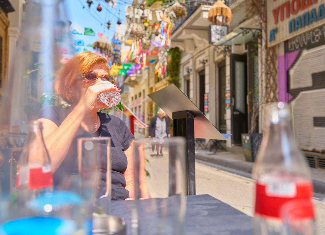 A woman staying hydrated on a New York City street, showing how to stay cool during July heat