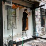 A painter working at an easel in a New York studio space, representing the focused time that artist residencies provide.