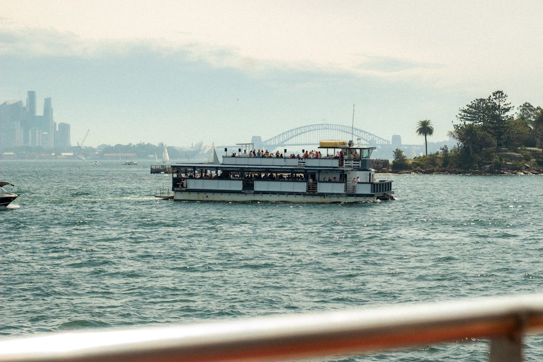 A woman standing on the deck of an NYC Ferry vessel with the Manhattan skyline visible in the background
