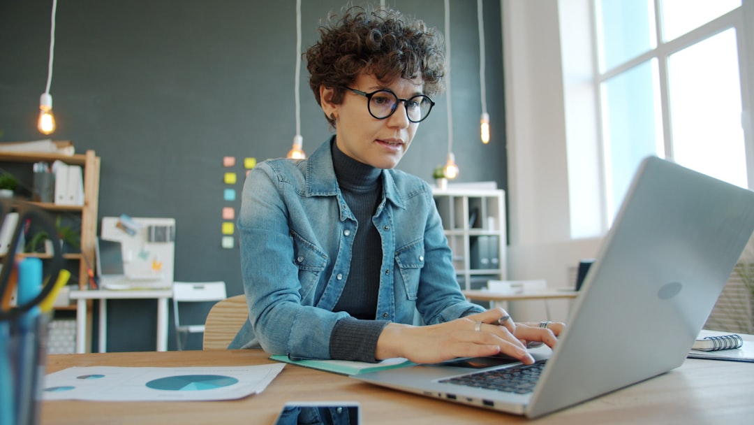 A freelancer pauses at her desk to manage burnout by stepping back from her screen and breathing