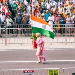 A woman in traditional dress waves the Indian flag during the India Day parade on Madison Avenue in New York City