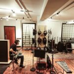 An independent artist recording vocals in an affordable studio space in New York City
