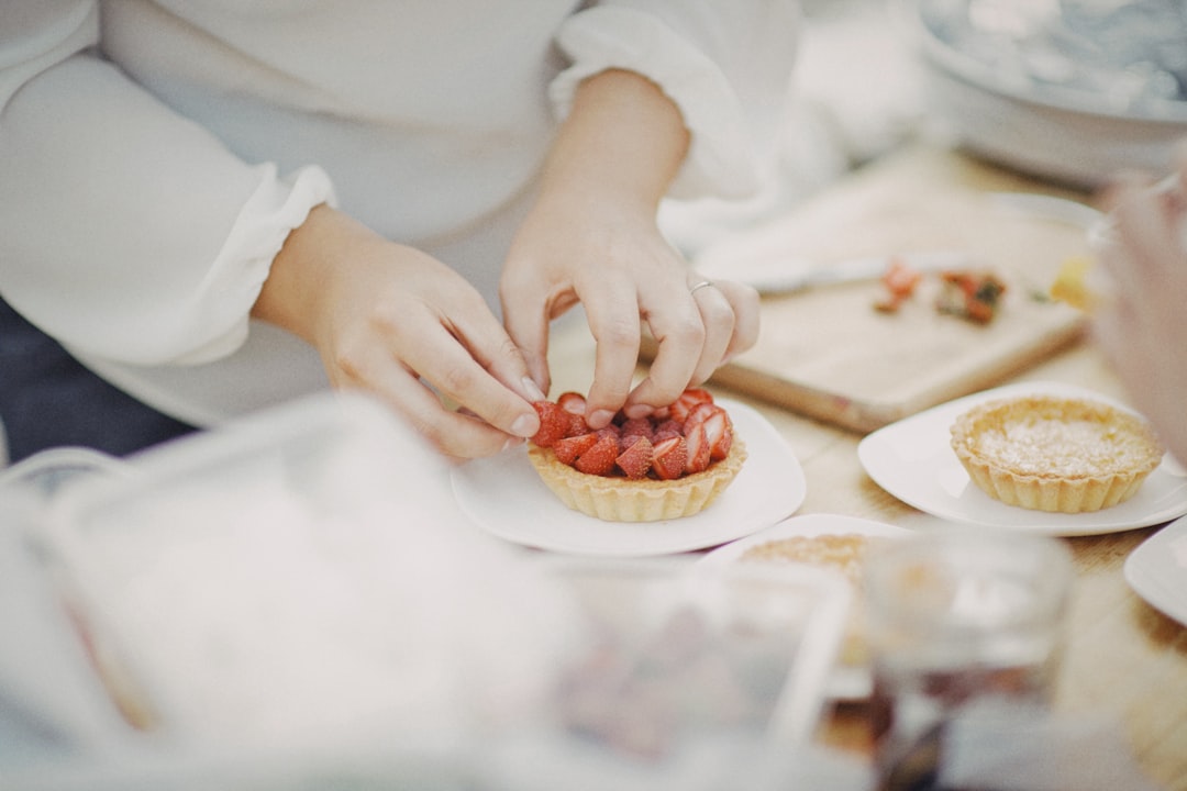 A pastry chef carefully plates a late summer dessert at a New York City restaurant, showcasing seasonal fruit.