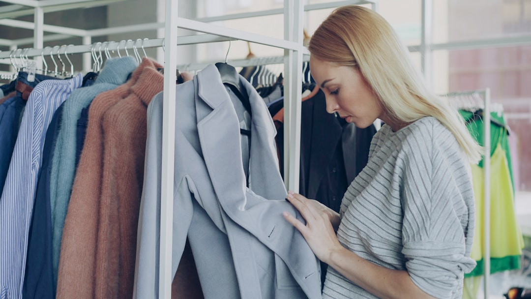 A woman examines ethically made garments while building a capsule wardrobe at a New York City independent boutique