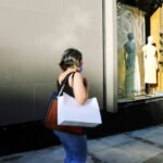 A focused woman carefully examining a designer jacket at New York City sample sales, building an intentional wardrobe.