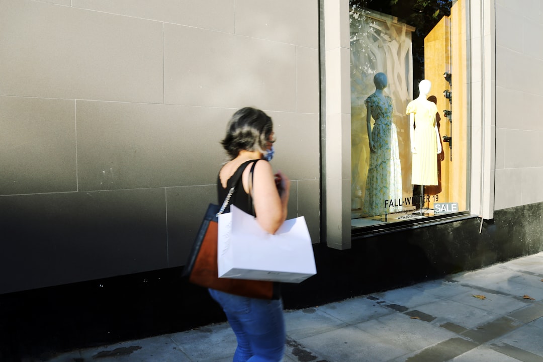 A focused woman carefully examining a designer jacket at New York City sample sales, building an intentional wardrobe.