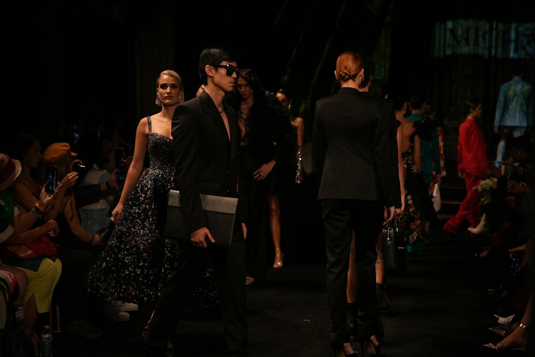An emerging designer adjusts a garment backstage before a New York Fashion Week runway show