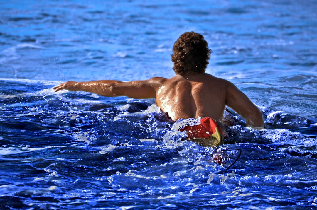A swimmer wading into the open water at Brighton Beach, representing the open-water culture of a New York City swimming club