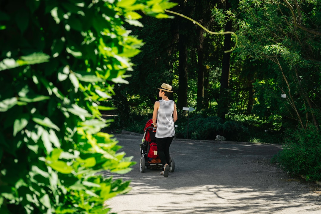 A woman walks along a tree-lined path at one of New York City's botanical gardens in autumn